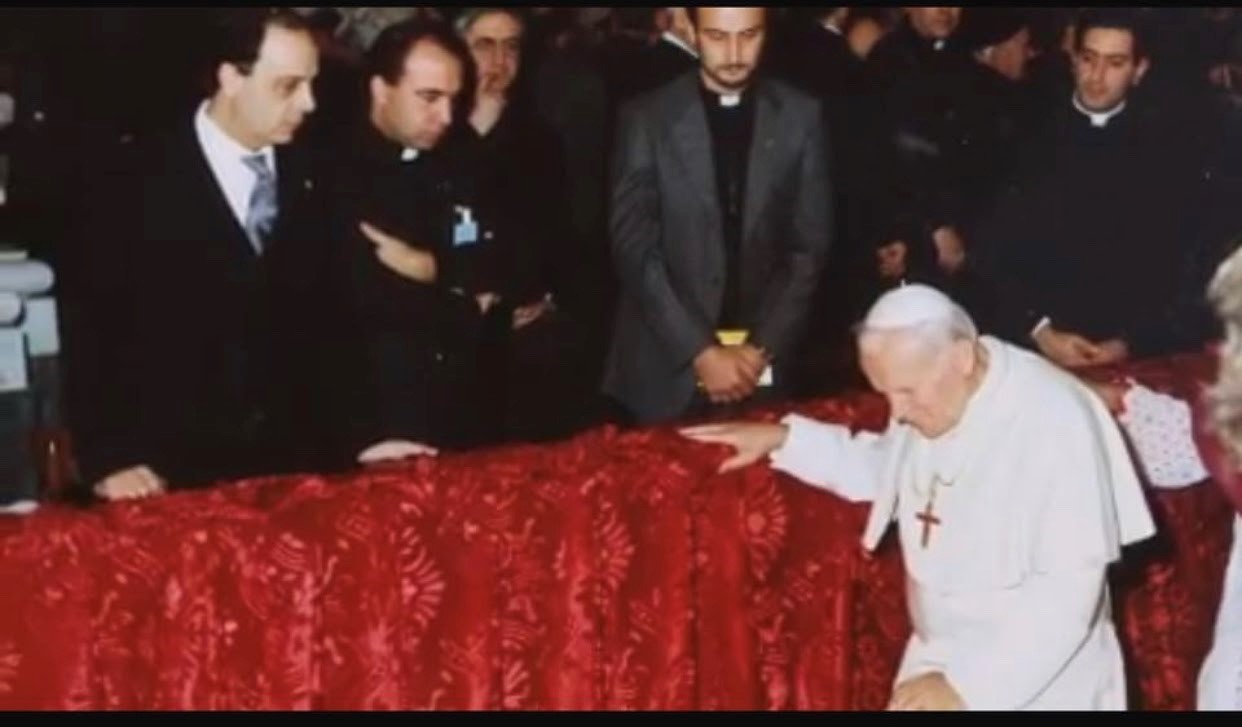 Papa Giovanni Paolo II si inginocchia davanti a Don Peppe