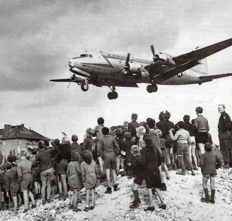 Alcuni berlinesi guardano un C-54 atterrare all'aeroporto di Berlino Tempelhof, 1948